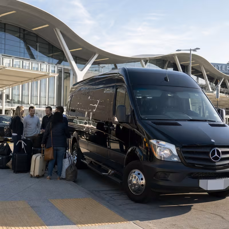 Group boarding a white charter bus for Airport Transportation transportation in Los Angeles