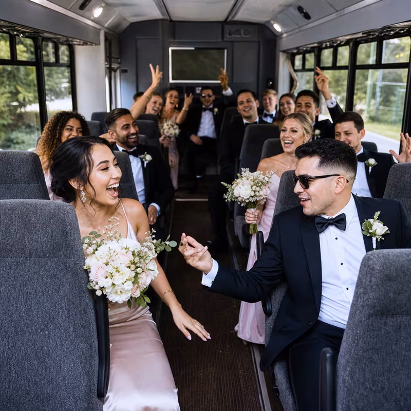 Group boarding a white charter bus for Wedding Transportation transportation in Los Angeles